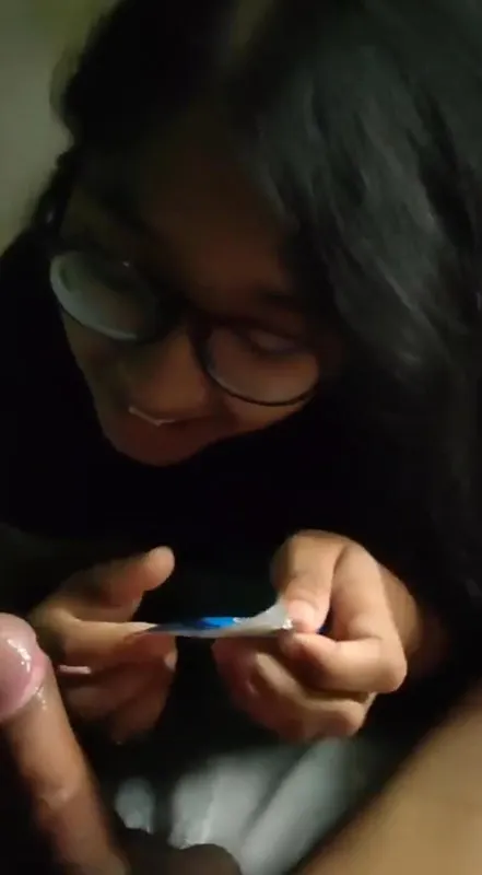 Indian girlfriend opening condom and shyly putting it on boyfriend’s hard dick